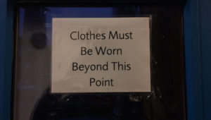A sign that says 'Clothes Must Be Worn Beyond This Point'