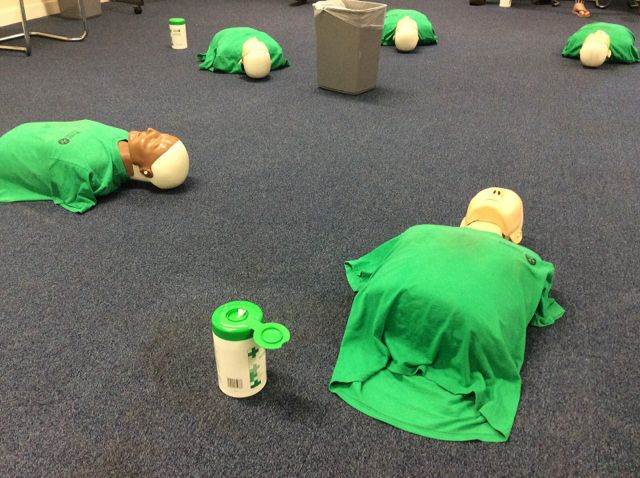 6 resuscitation dolls lined up on the floor ready for CPR training