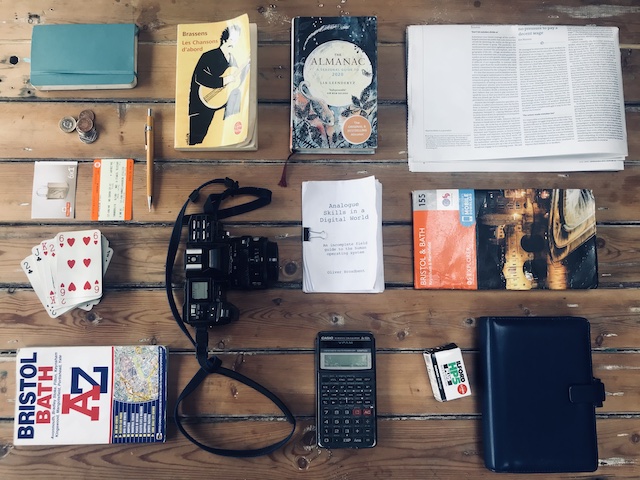 Image showing a range objects including a diary, a book of lyrics, a newspaper, cards, tickets, cash, maps, calculator and a camera, all things associated with Analogue Skills