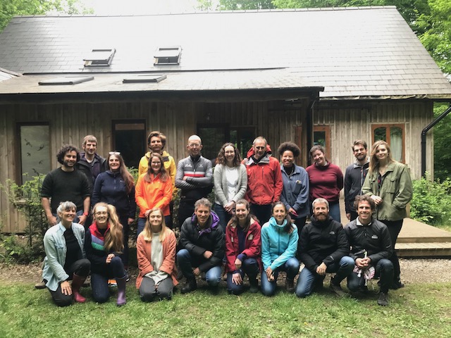 20 people standing outside the Oak House at Hazel Hill Wood. This group was the first cohort of participants on the Regenerative Design Lab